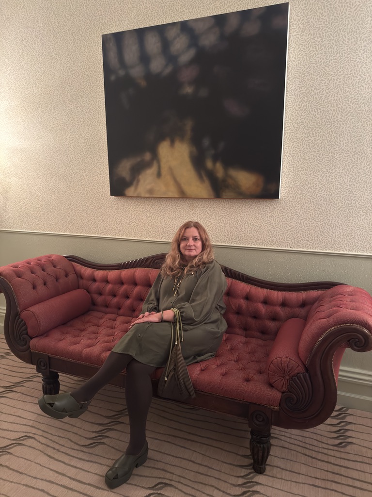 Ludmila seated beneath a painting at the Park Hotel in Kenmare